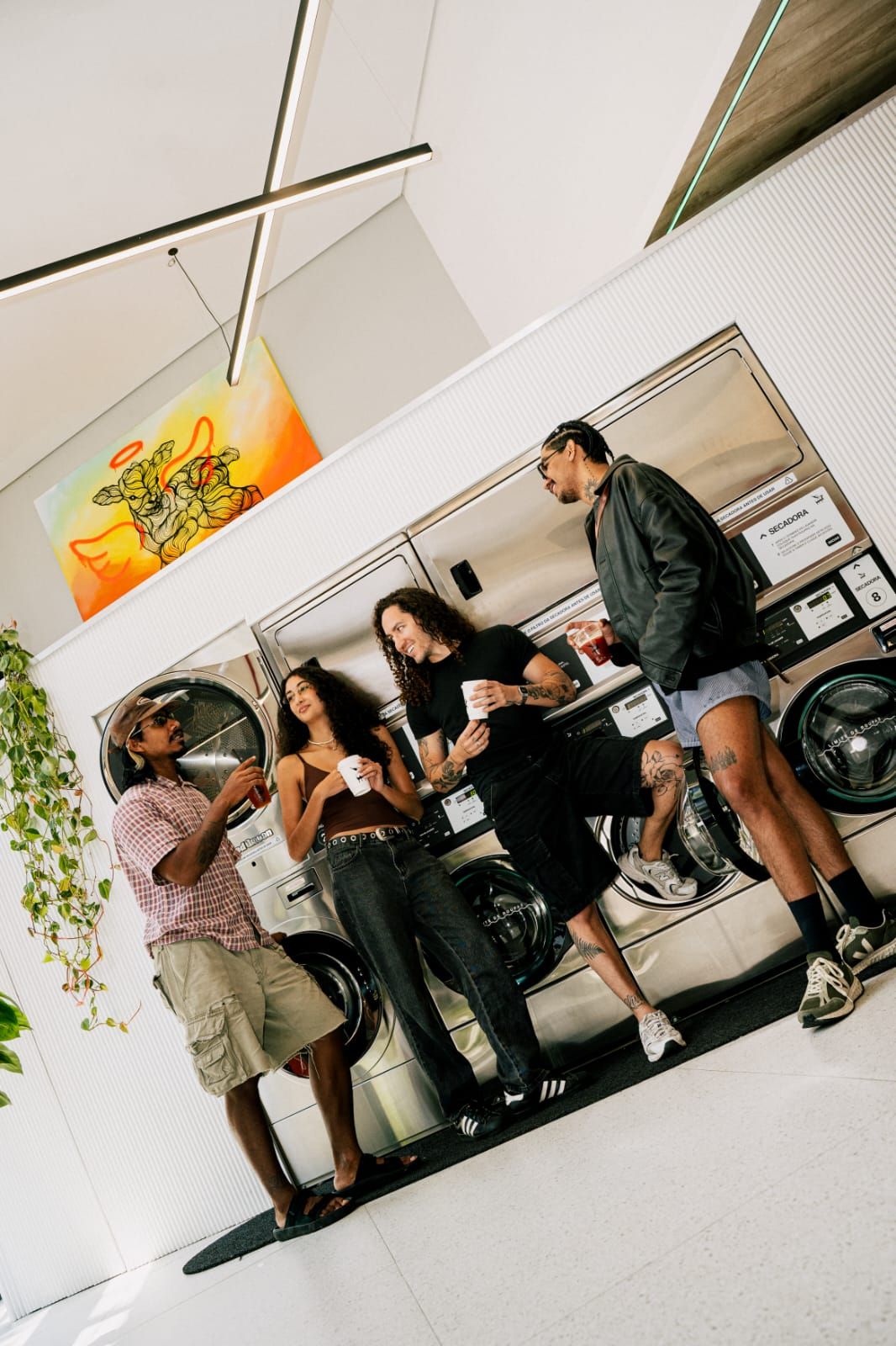 Pessoas tomando café encostadas nas máquinas