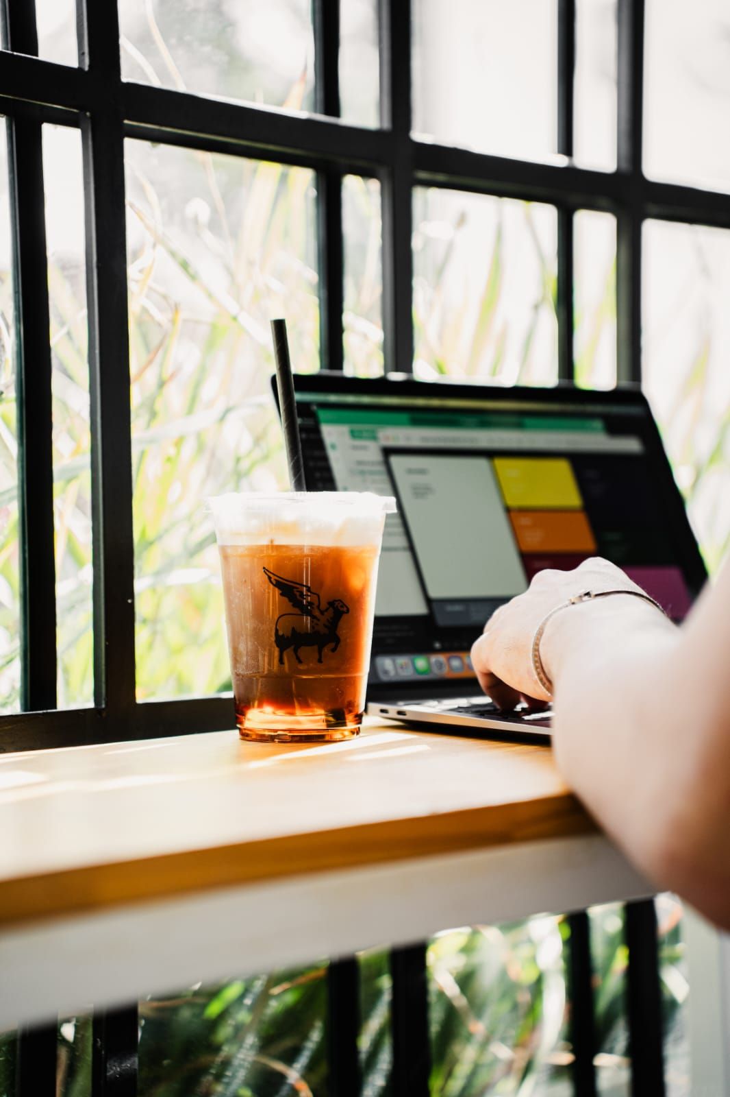 Pessoa trabalhando no laptop com café ao lado